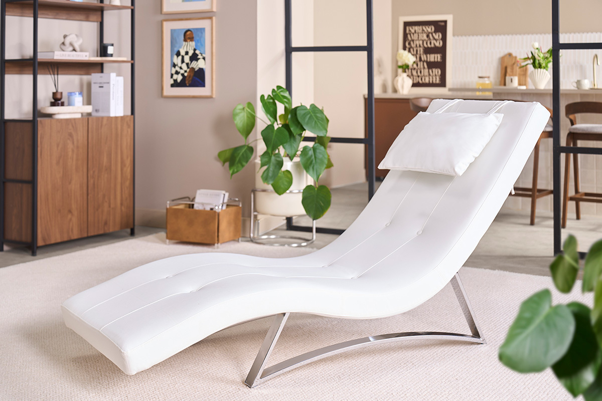 Chaise longue design BARTY in bianco con cuscino, vista a 3/4 in un interno moderno.