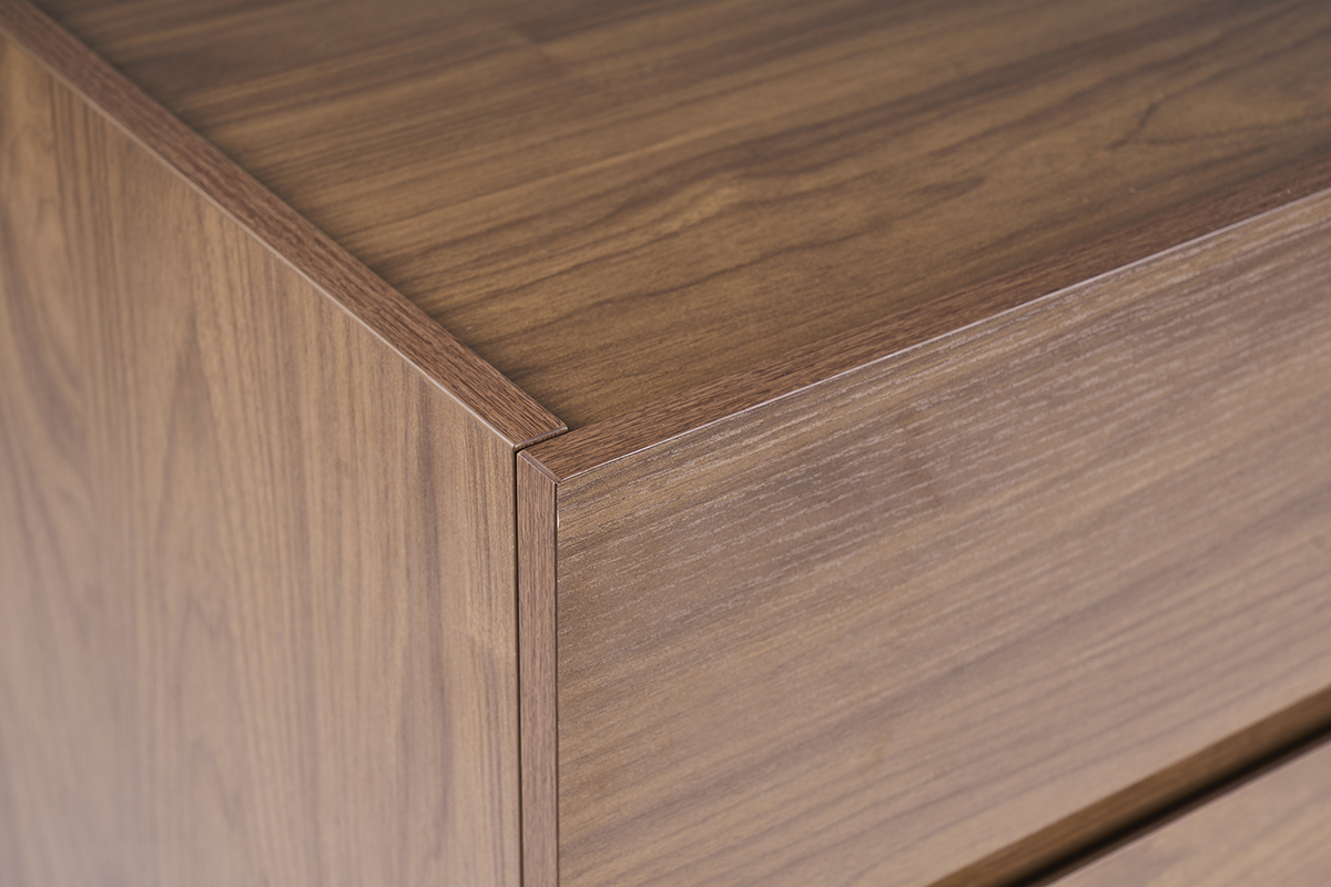 Dettaglio del com� SANAA finitura in noce scuro con venature visibili.