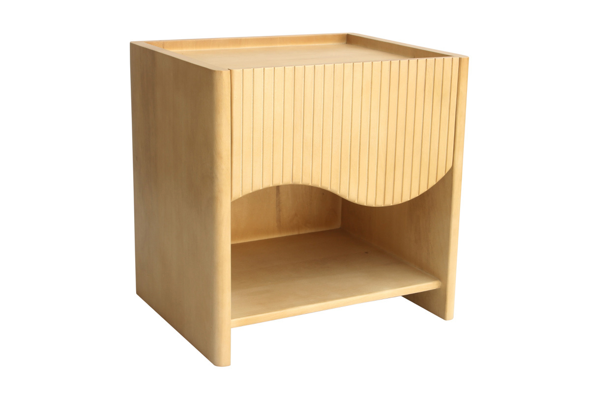 Comodino in legno di mango con cassetto ondulato intagliato e nicchia aperta, vista da tre quarti.