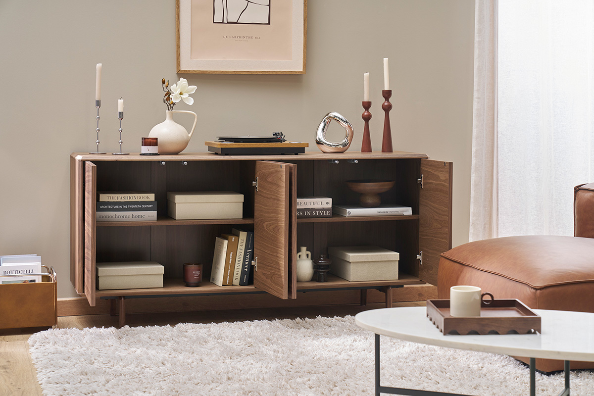 Buffet in noce con porte aperte con libri e oggetti decorativi.