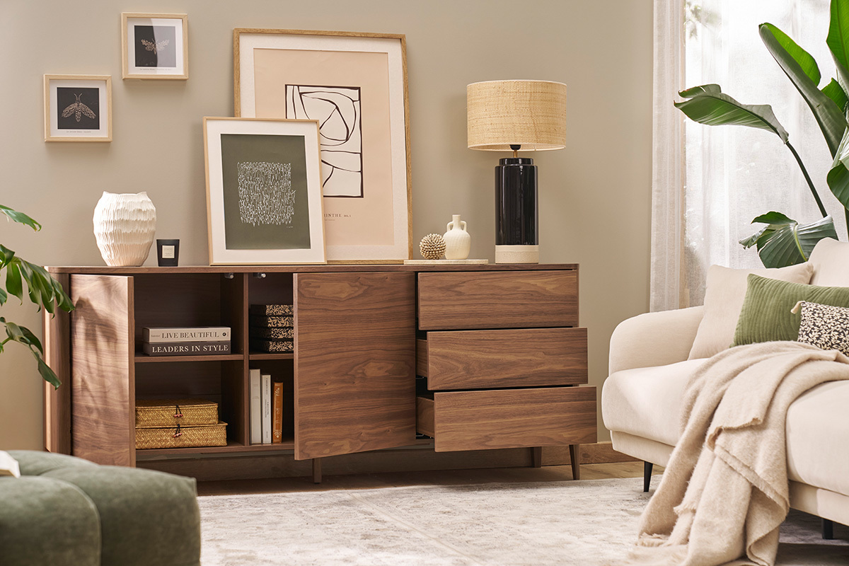 Buffet in legno scuro noce con porte aperte e cassetti in un soggiorno decorato.