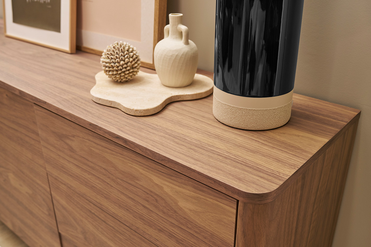 Buffet in noce scuro con oggetti decorativi sopra, vista angolare.