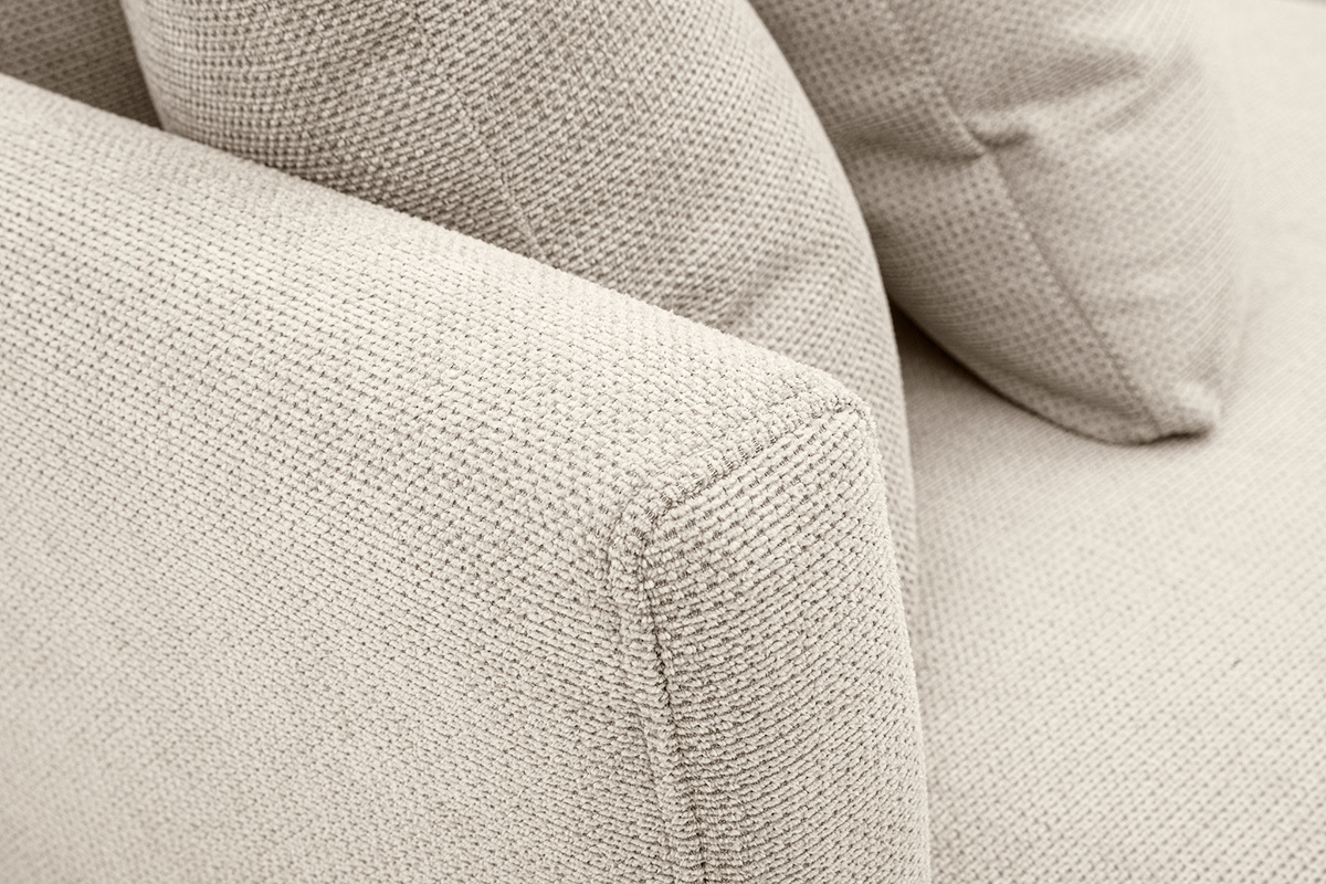 Dettaglio del divano a 3 posti in tessuto ciniglia beige con cuscini sfoderabili, angolazione ravvicinata