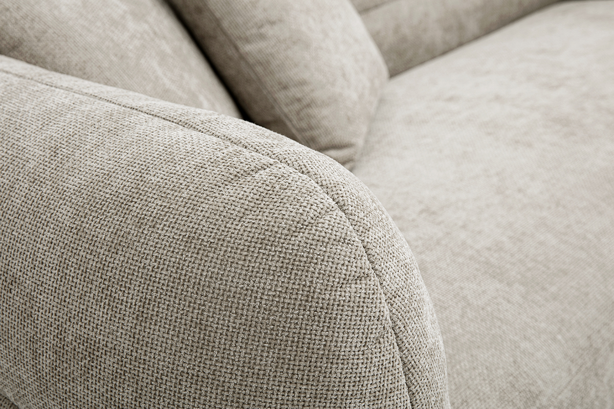 Primo piano di un divano beige in tessuto effetto velluto testurizzato.