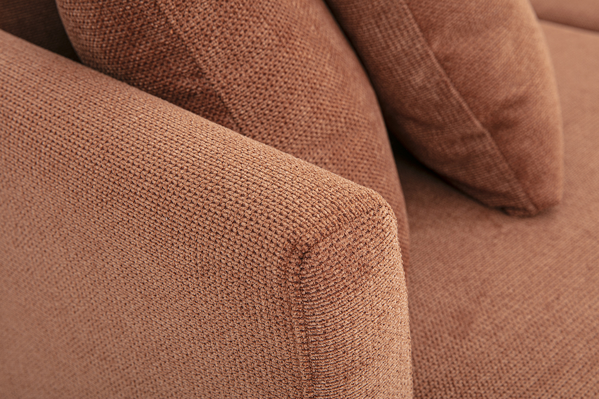 Dettaglio di un divano a 3 posti in tessuto chenille color terra bruciata con braccioli e cuscini