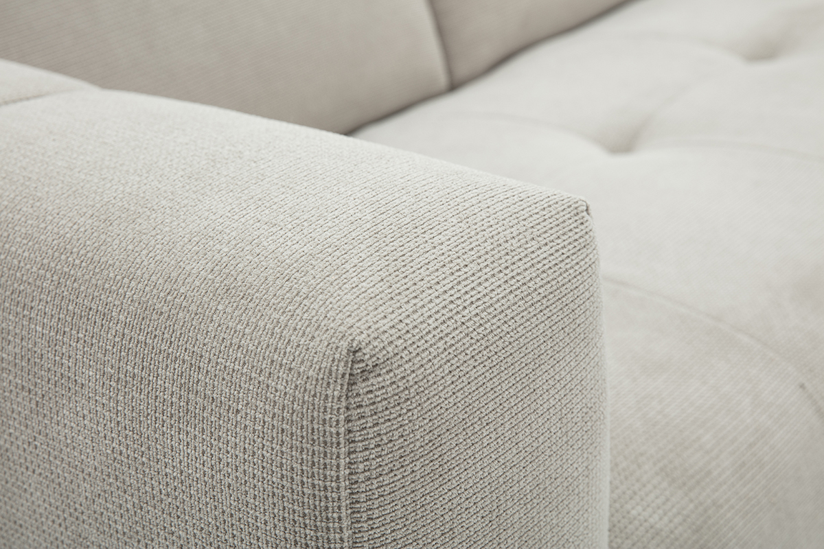 Primo piano sul tessuto chenille beige del divano ad angolo NORELL.