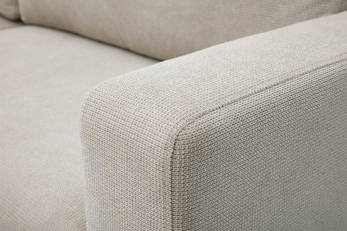 Zoom sul bracciolo e sulla seduta del divano angolare convertibile NESTO in tessuto chenille beige.