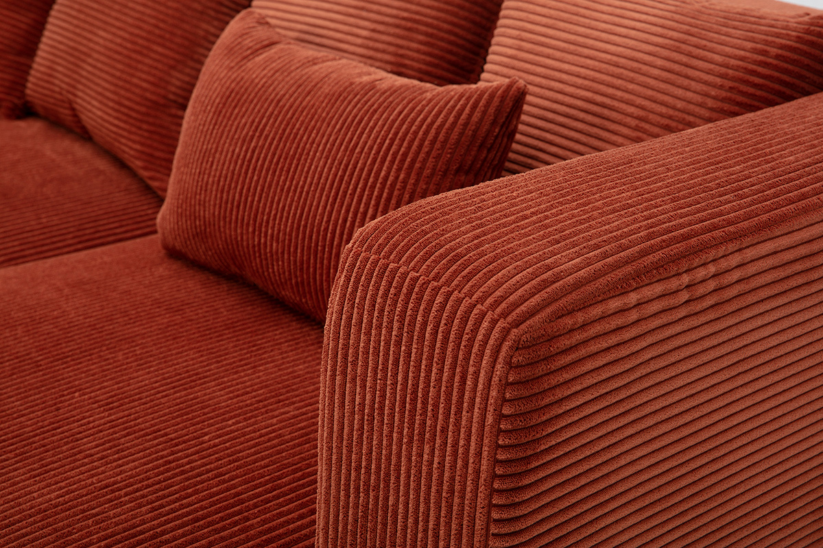 Dettaglio del divano angolare destro a 3 posti in tessuto velluto a coste terracotta, cuscini inclusi.