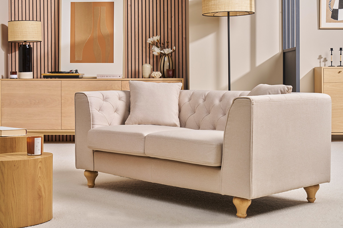Divano beige 2 posti MONTAIGNE con braccioli e schienale capitonn, vista frontale.