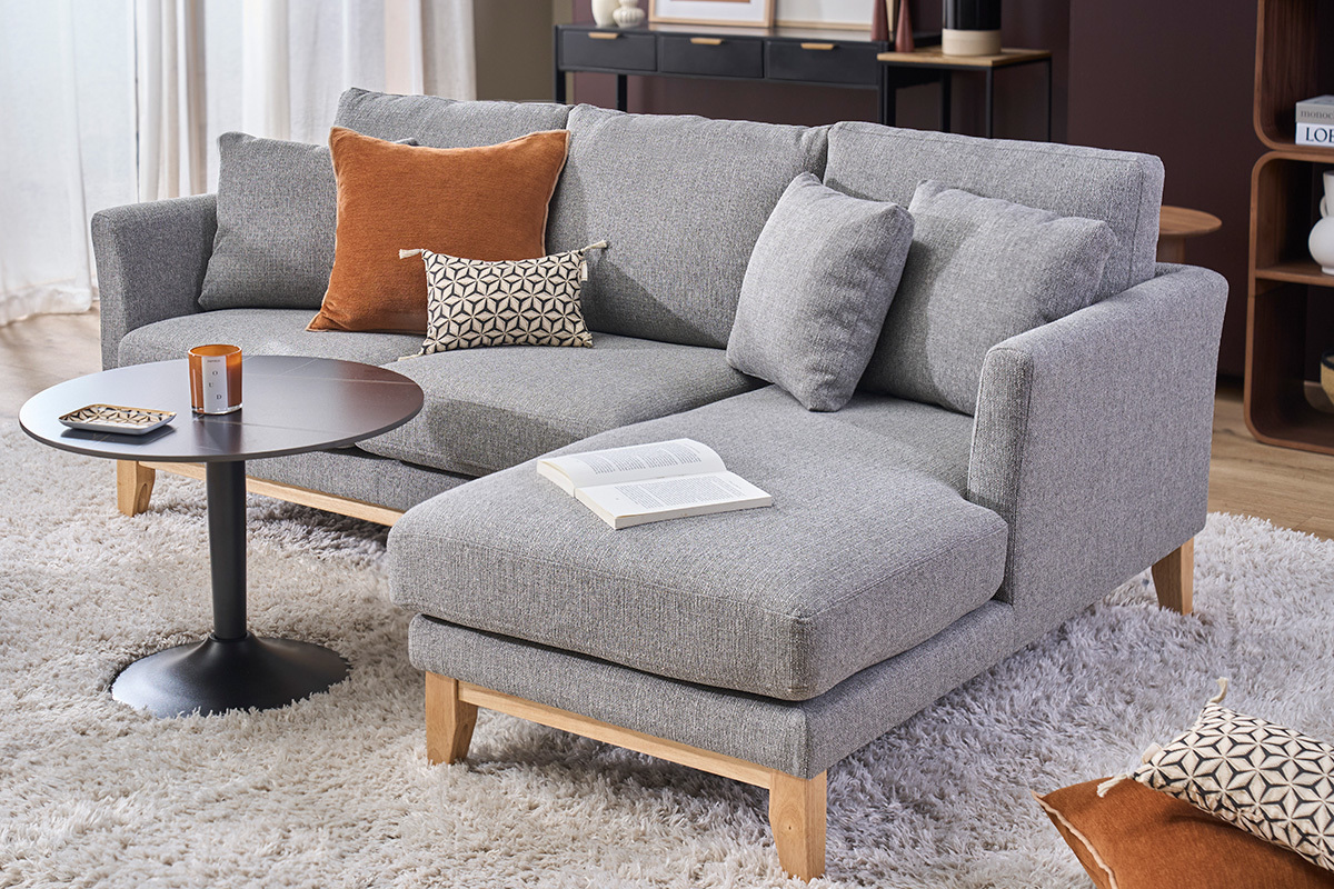 Divano angolare destro scandinavo grigio chiaro con cuscini e tavolino, vista laterale