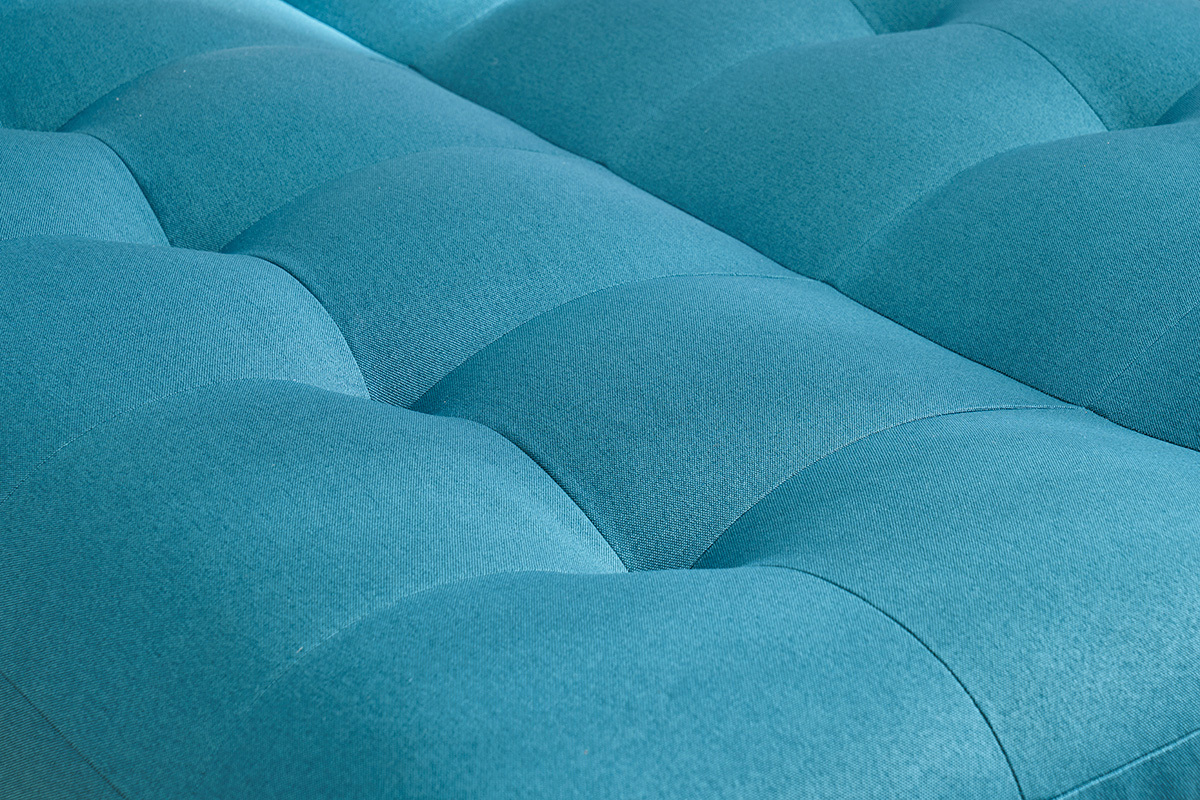 Primo piano sul tessuto blu pavone del divano letto YUMI.