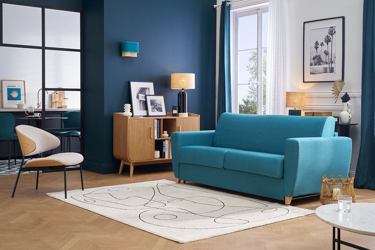 Divano letto blu petrolio a 3 posti, vista frontale, in un soggiorno moderno.