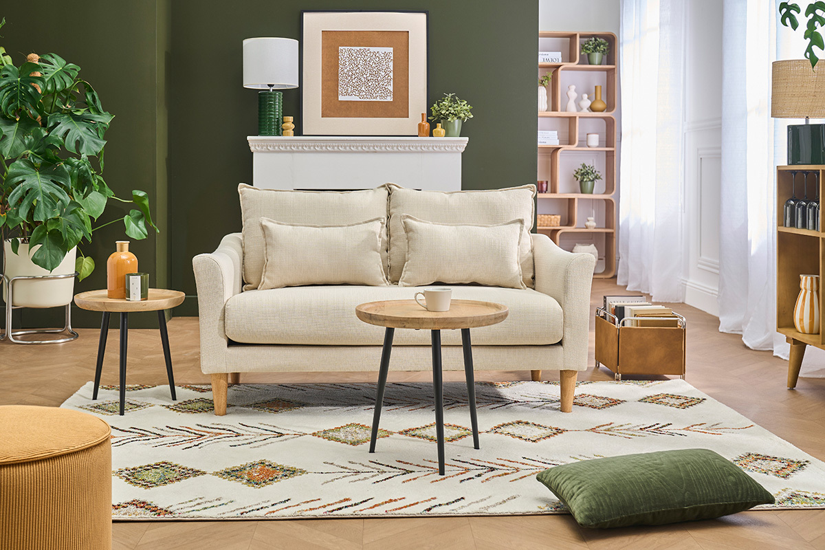 Divano scandinavo a 2 posti KATE in tessuto beige, con cuscini, in un soggiorno moderno.