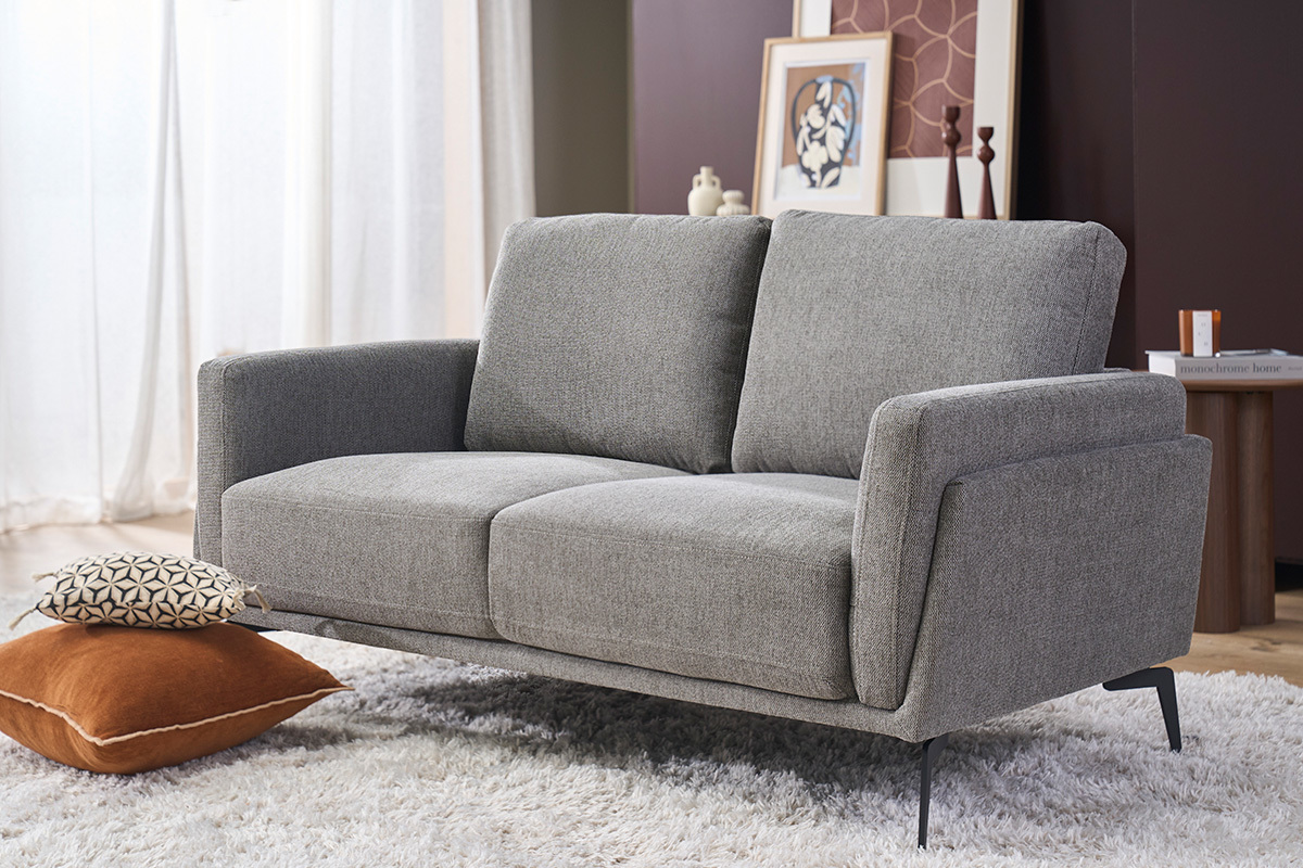 Divano design a 2 posti in tessuto effetto velluto grigio scuro con piedini in metallo nero, vista frontale.