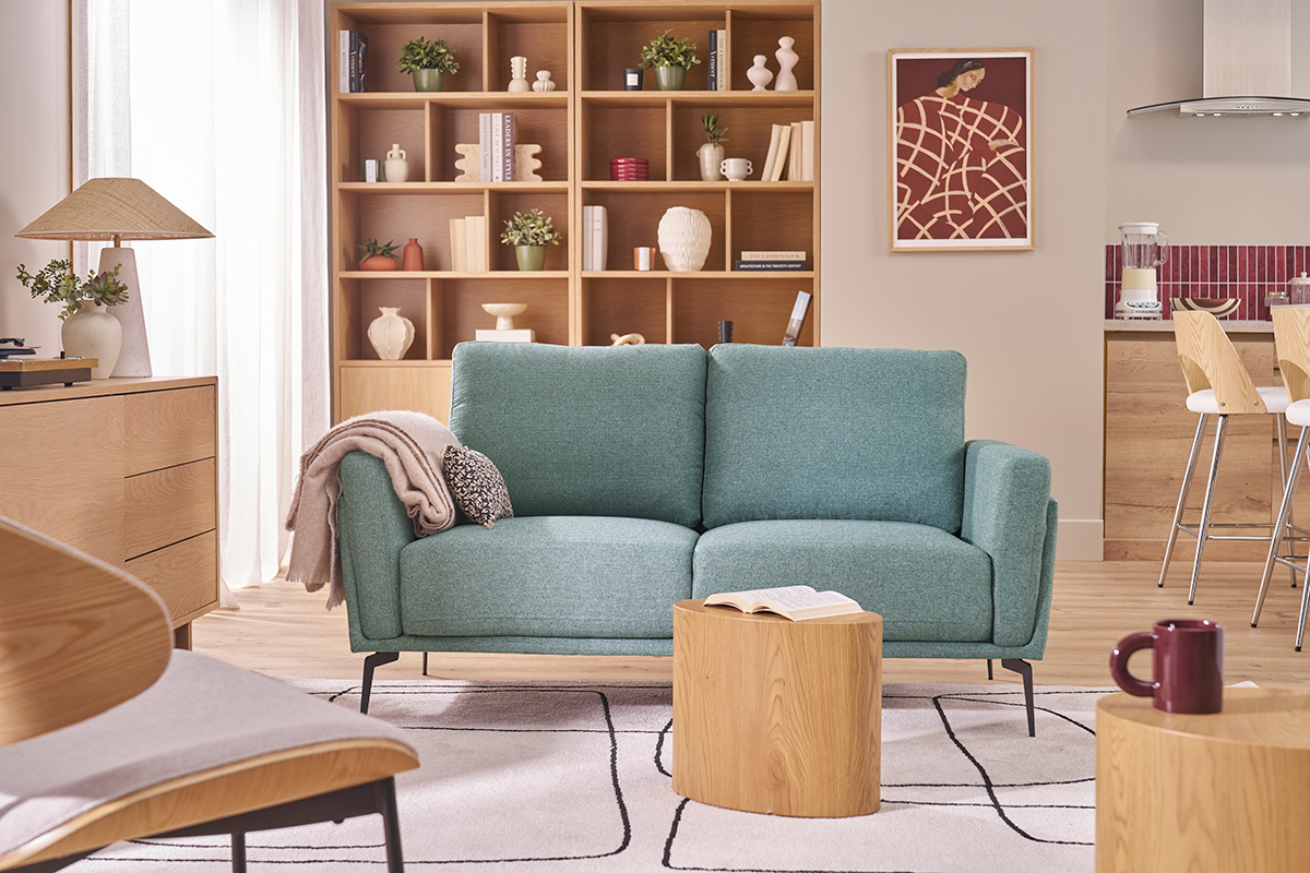 Divano verde grigio a 2 posti in tessuto e metallo nero in un soggiorno contemporaneo.