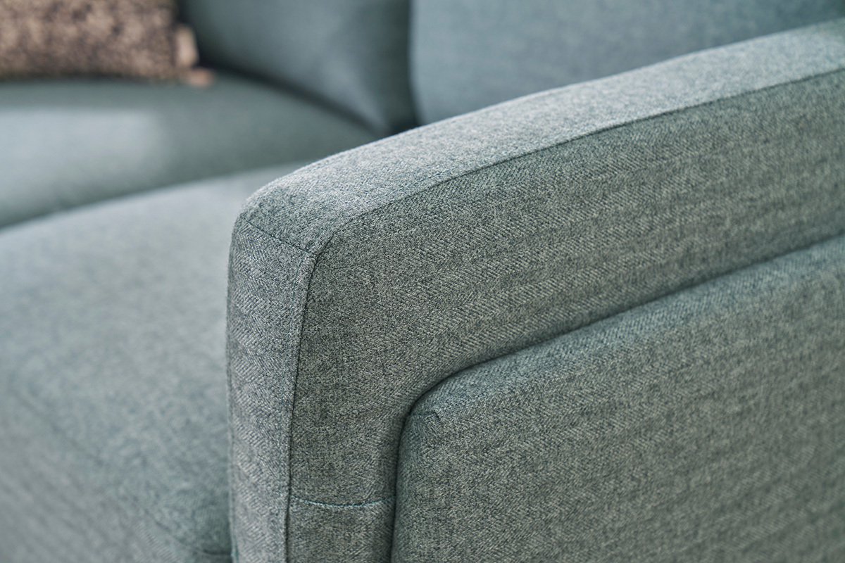 Bracciolo di un divano design a 2 posti verde grigio.