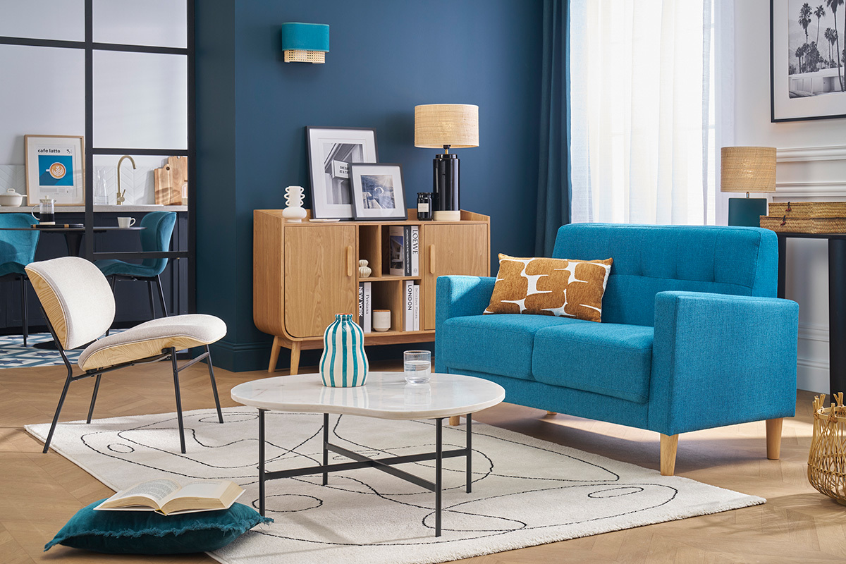 Divano scandinavo a 2 posti blu pavone in tessuto e legno chiaro MOON, vista d'insieme in un soggiorno.