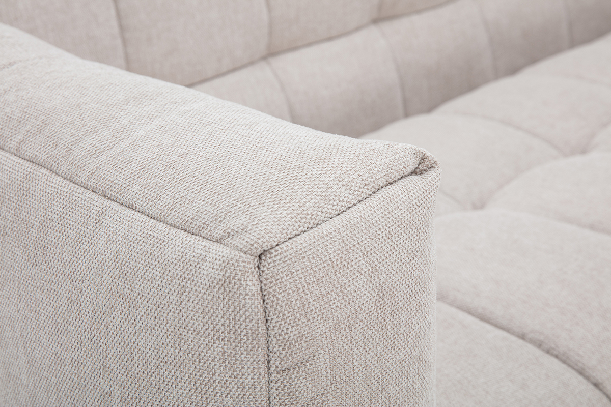 Vista ravvicinata di un divano beige in tessuto effetto velluto testurizzato.