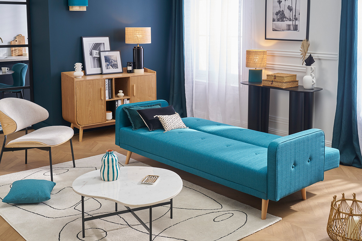 Divano letto scandinavo blu e in legno chiaro in modalit letto in un soggiorno moderno.