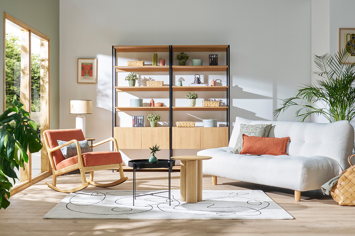 Divano letto YUMI in soggiorno moderno con poltrona e scaffali, vista frontale.