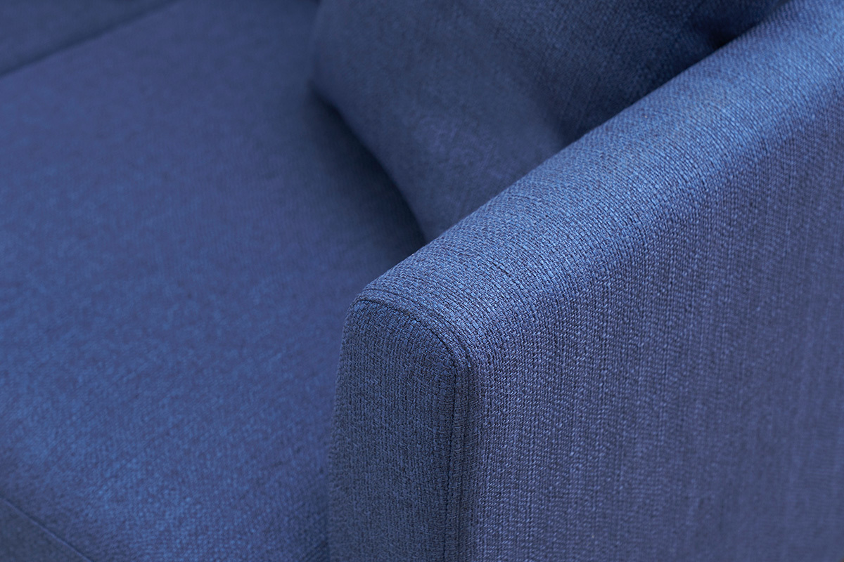 Primo piano del bracciolo del divano scandinavo blu scuro OSLO in tessuto.