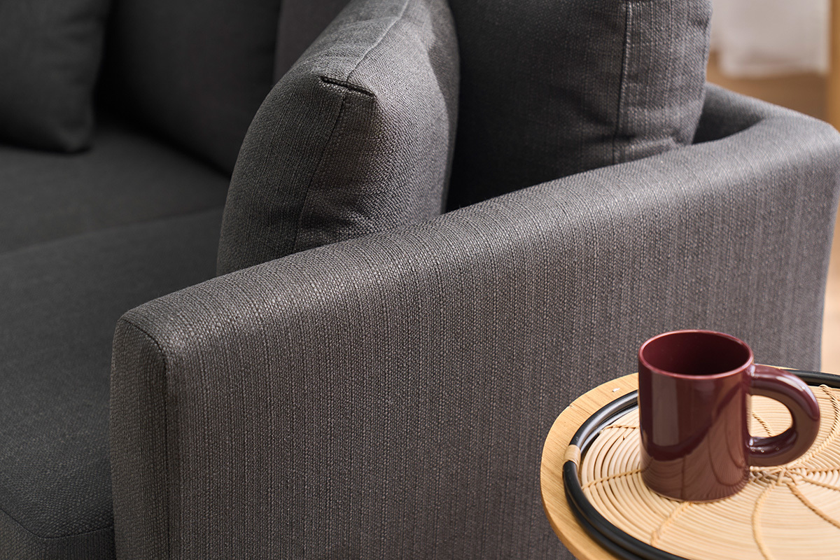 Divano grigio scuro a 2 posti OSLO in primo piano con una tazza su un tavolo in legno chiaro.