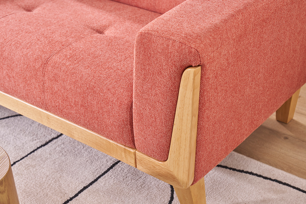 Primo piano su bracciolo e struttura in legno chiaro del divano terracotta.