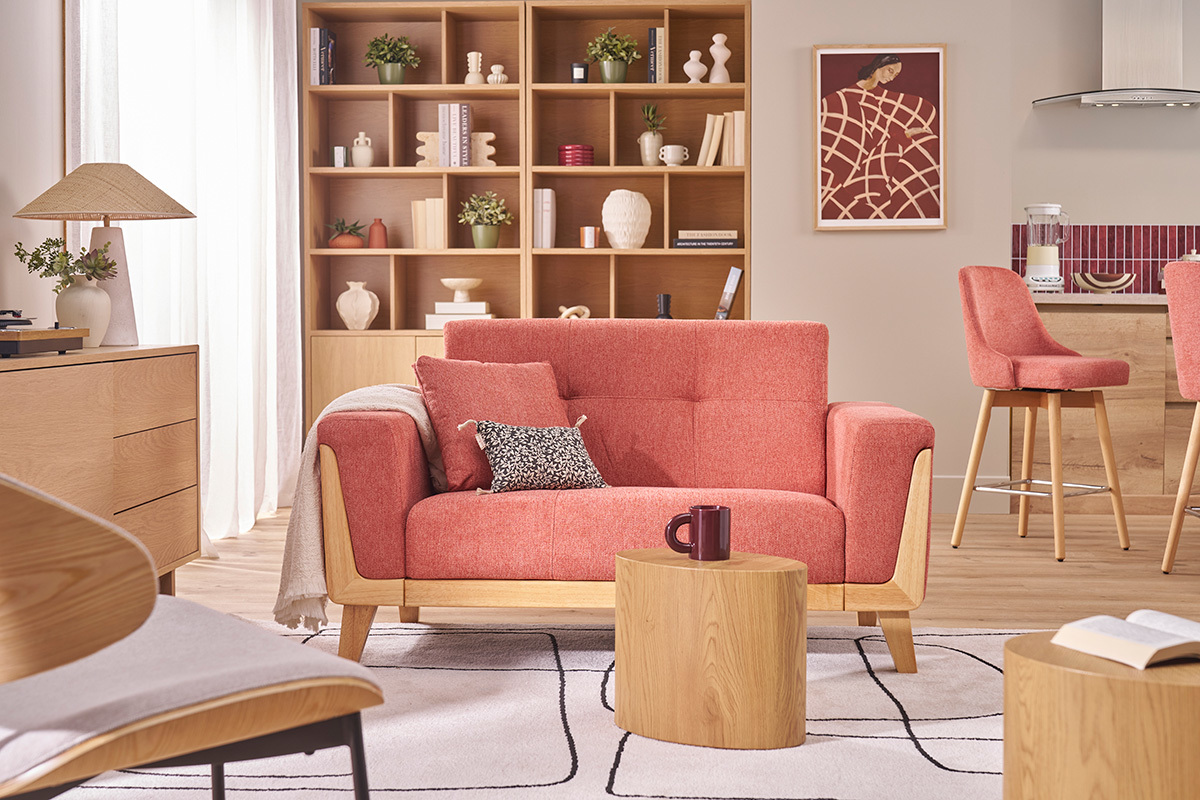 Divano scandinavo terracotta a due posti con legno chiaro in un soggiorno moderno.