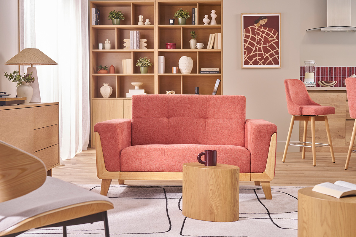 Divano scandinavo a 2 posti in tessuto, vista frontale, con tavolo in legno.