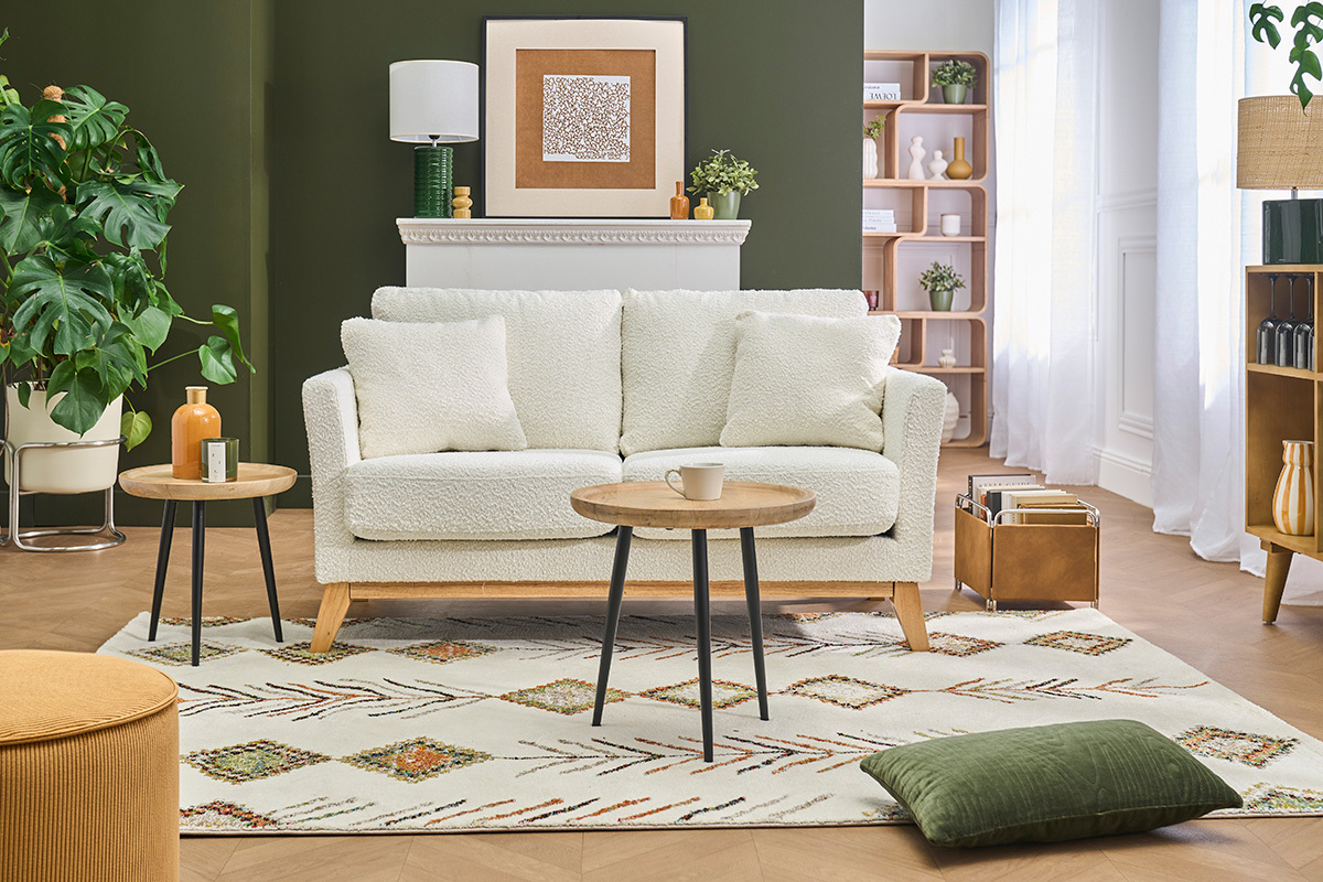 Divano scandinavo sfoderabile per 2 posti in tessuto boucl� bianco crema, visto di fronte in un soggiorno.