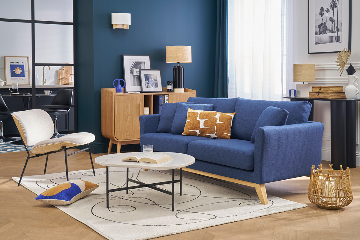 Divano scandinavo blu a 3 posti con cuscini, vista frontale in un salotto moderno.