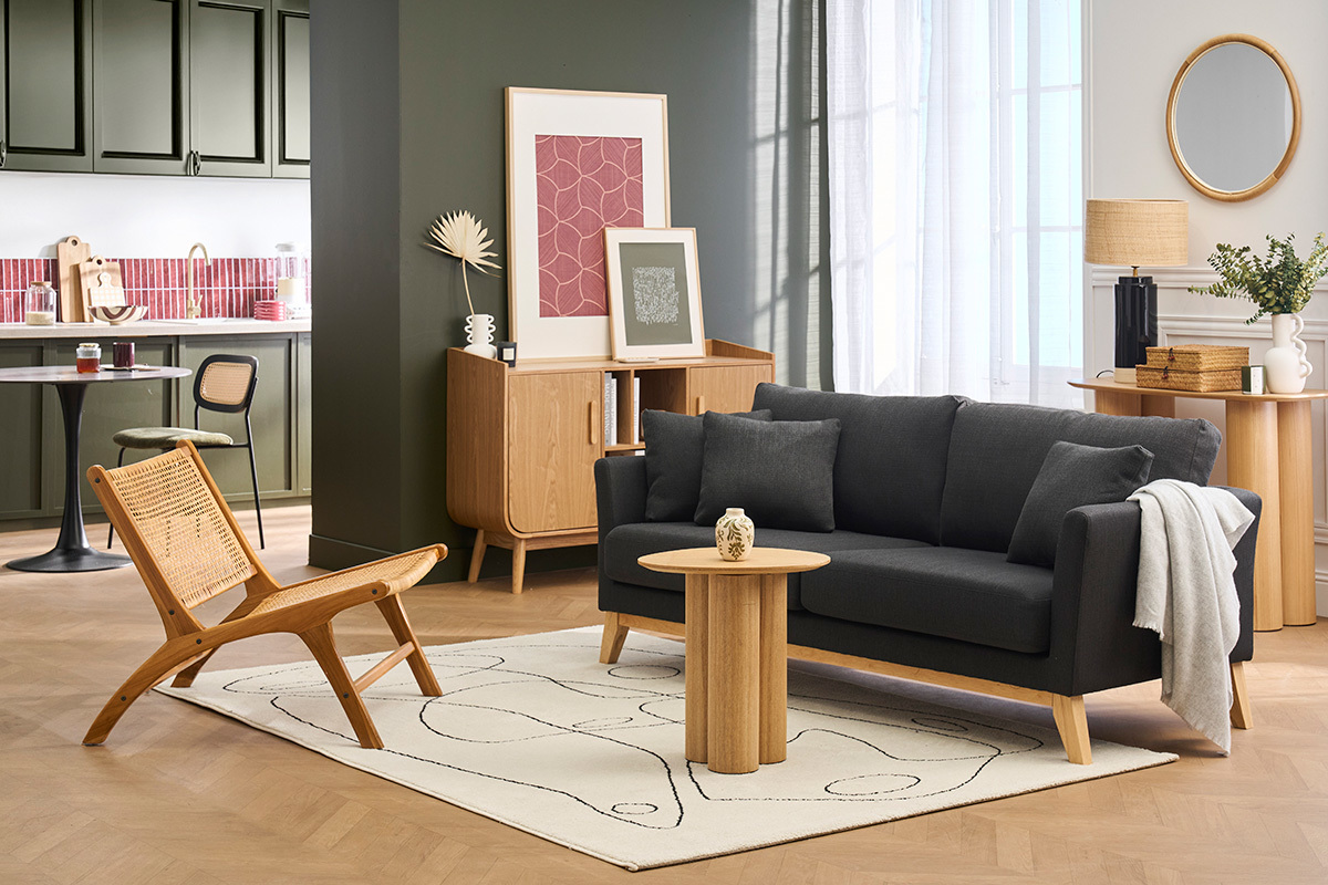 Divano scandinavo 3 posti grigio scuro su tappeto con tavolino e sedia in legno, interno moderno.