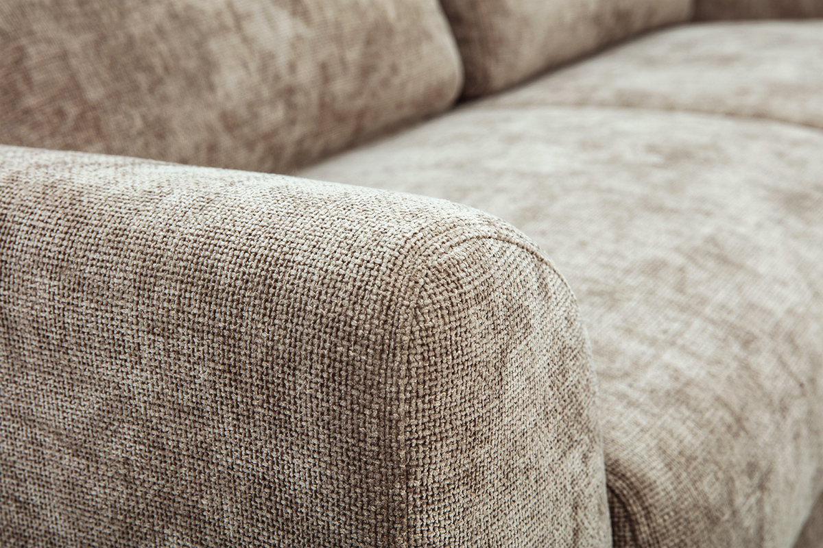 Primo piano sul bracciolo di un divano a 3 posti in tessuto effetto velluto testurizzato color talpa.