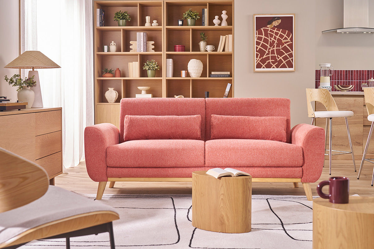 Divano scandinavo a tre posti e tavolo cilindrico in legno in un soggiorno moderno.