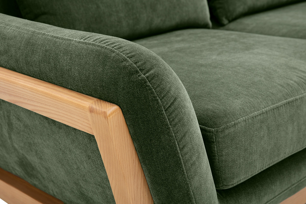 Dettaglio del divano scandinavo a 2 posti in tessuto velluto verde kaki con struttura in legno chiaro.