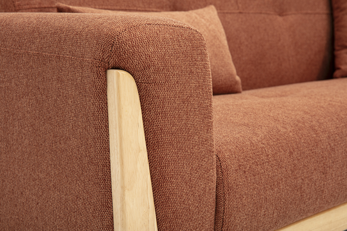 Dettaglio del divano scandinavo a 3 posti in tessuto color terra bruciata con bracciolo in legno chiaro.
