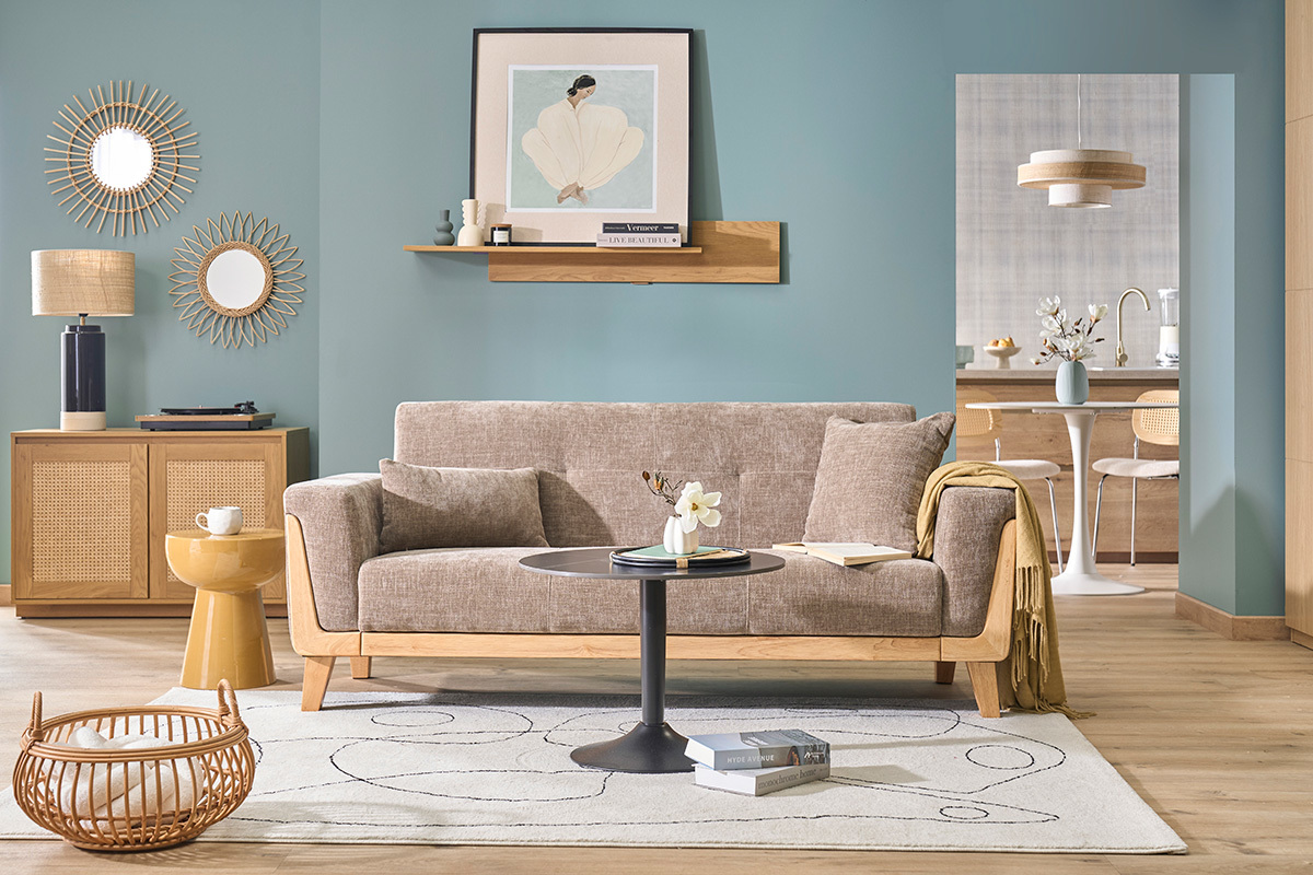 Canap� scandinavo a 3 posti in tessuto taupe e legno chiaro, vista d'insieme in un soggiorno.