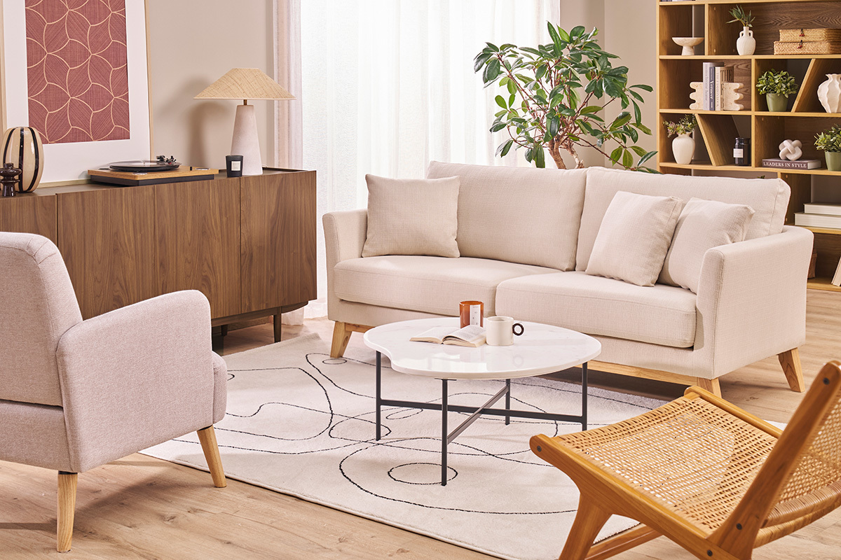 Divano scandinavo 3 posti beige, piedi in legno chiaro, con cuscini in salotto moderno.
