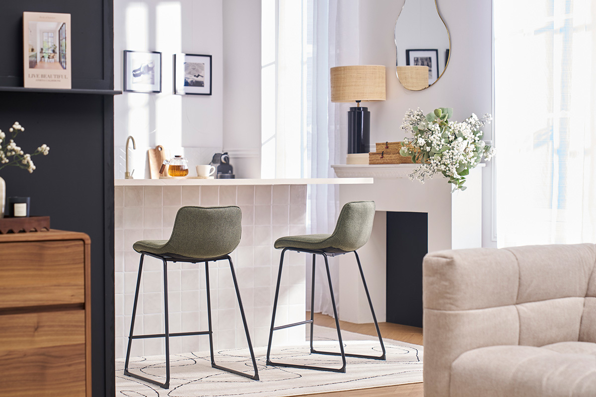 Lampada da tavolo nera con paralume in rabane su uno scaffale in una cucina luminosa.