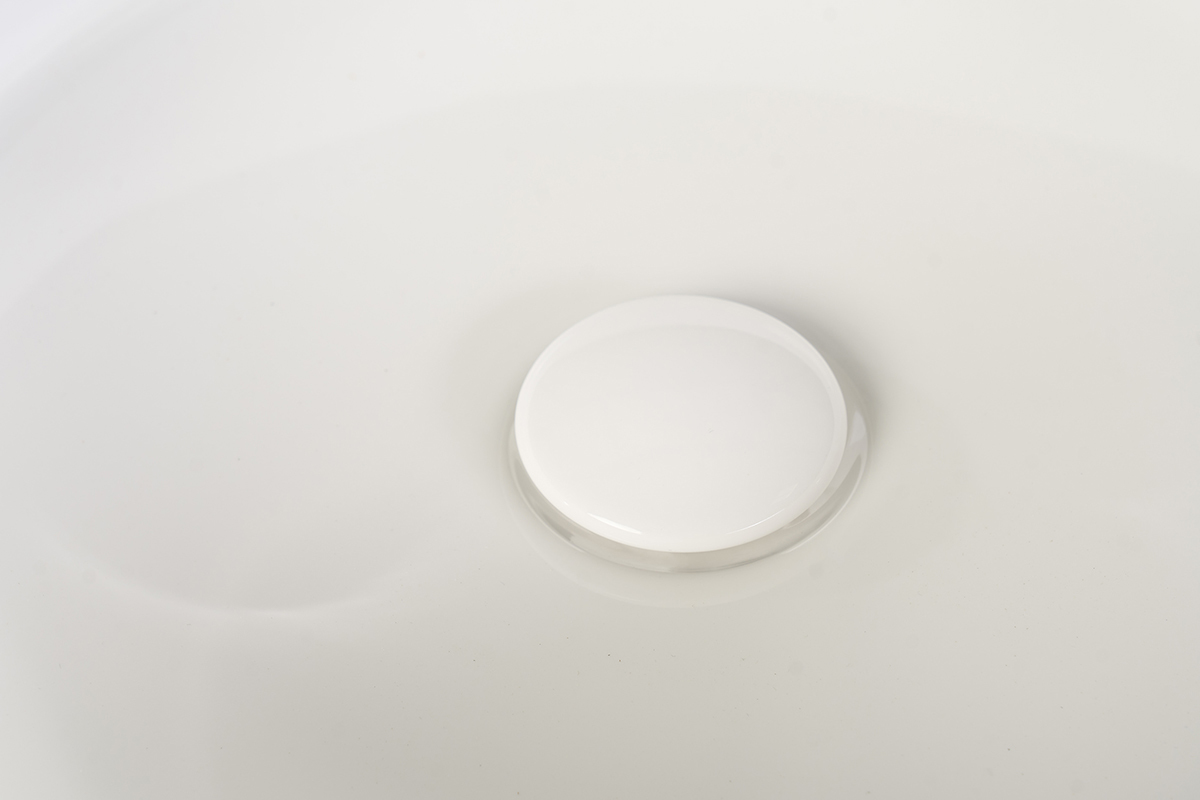 Lavabo rotondo in ceramica bianca con scarico, vista dall'alto