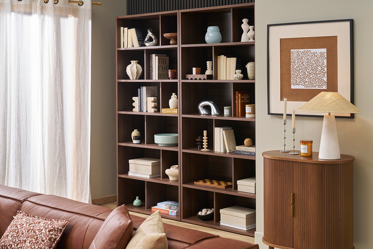 Libreria in noce scuro con 12 scomparti, libri e decorazioni, vista dall'interno.