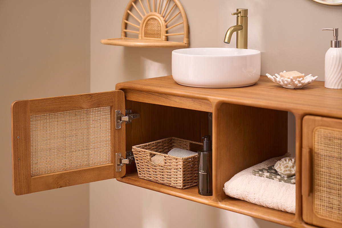 Mobile da bagno in teak con un armadio aperto, lavabo bianco e accessori decorativi