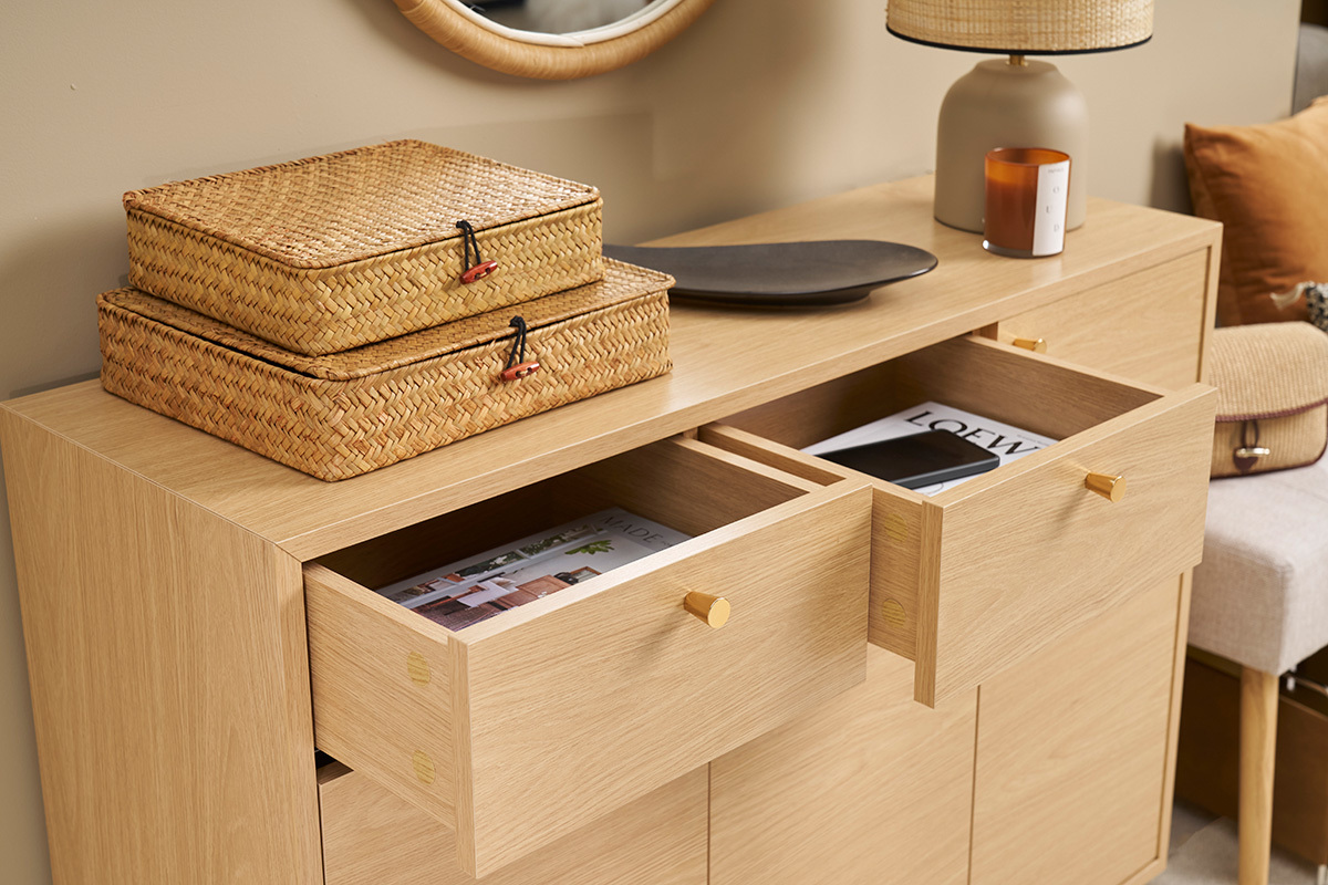 Mobile da ingresso in legno chiaro con cassetti aperti e oggetti sopra, vista da 3/4.