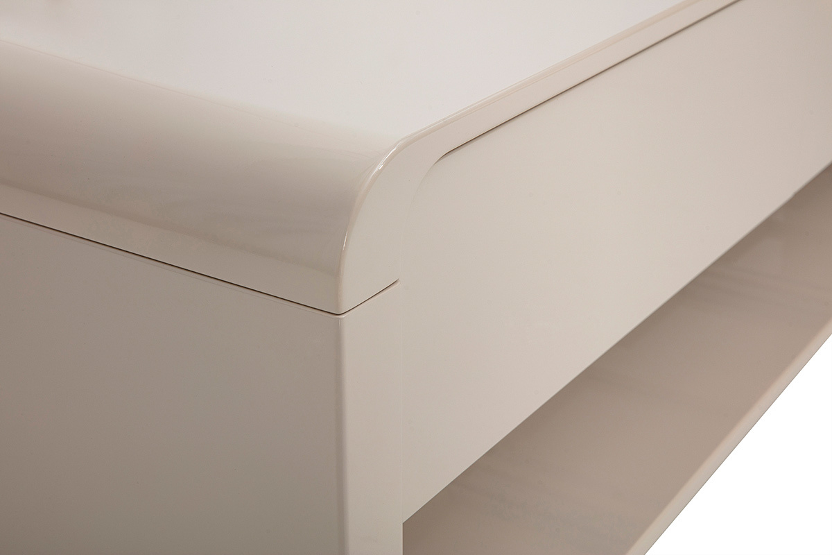 Dettaglio del mobile TV beige lucido con angolo arrotondato e nicchia aperta.