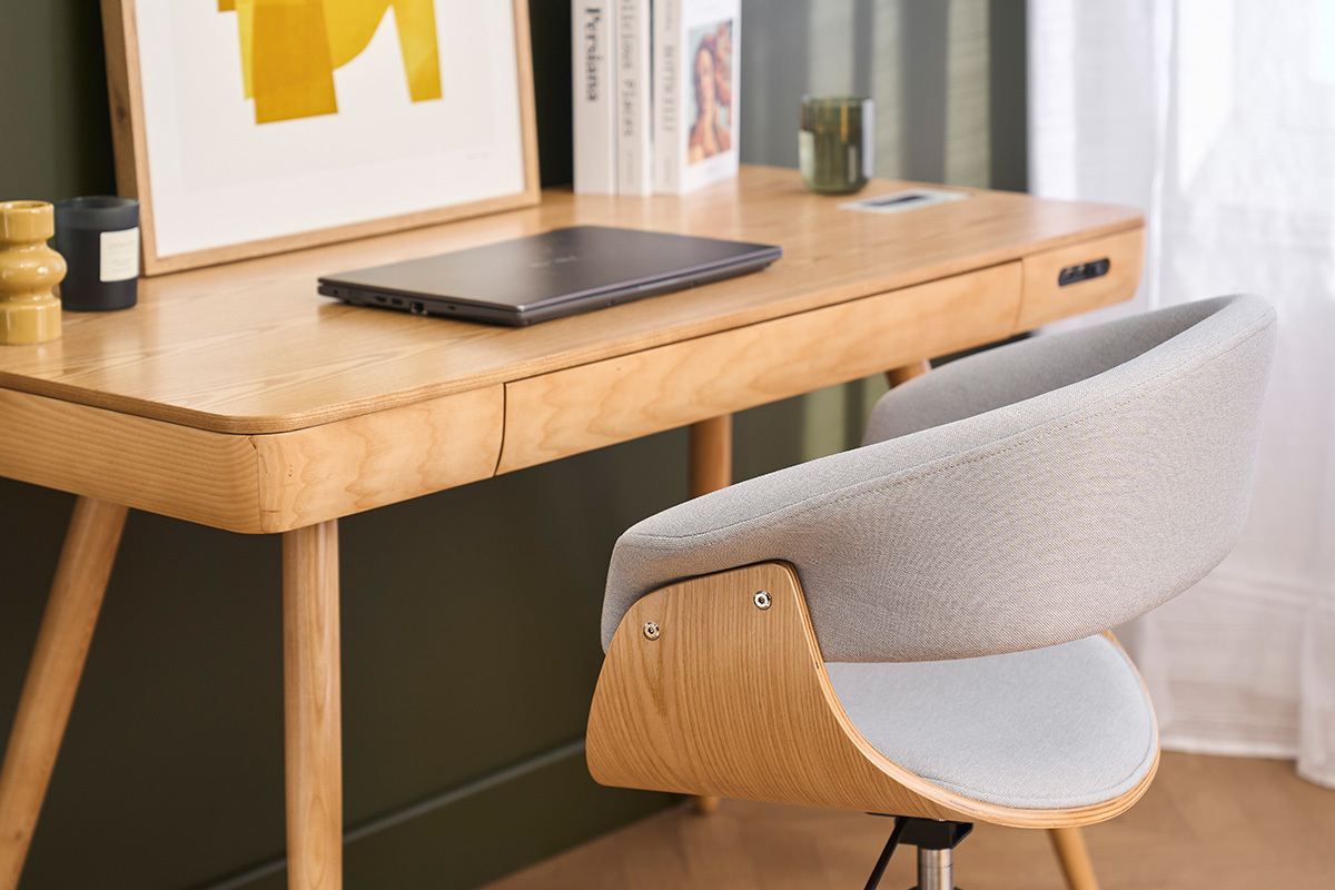 Sedia da ufficio OKTAV in tessuto grigio chiaro, vista da dietro davanti a una scrivania in legno chiaro.