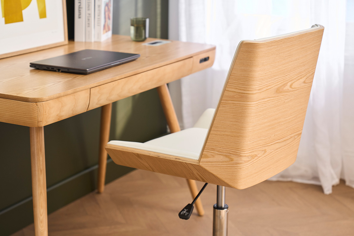 Sedia da ufficio con ruote MELKIOR, legno chiaro e seduta bianca, vicino a una scrivania in legno.