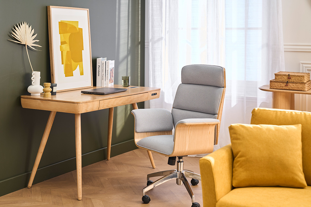 Poltrona da ufficio design ELON in tessuto e legno chiaro, davanti a una scrivania in legno con decorazione.