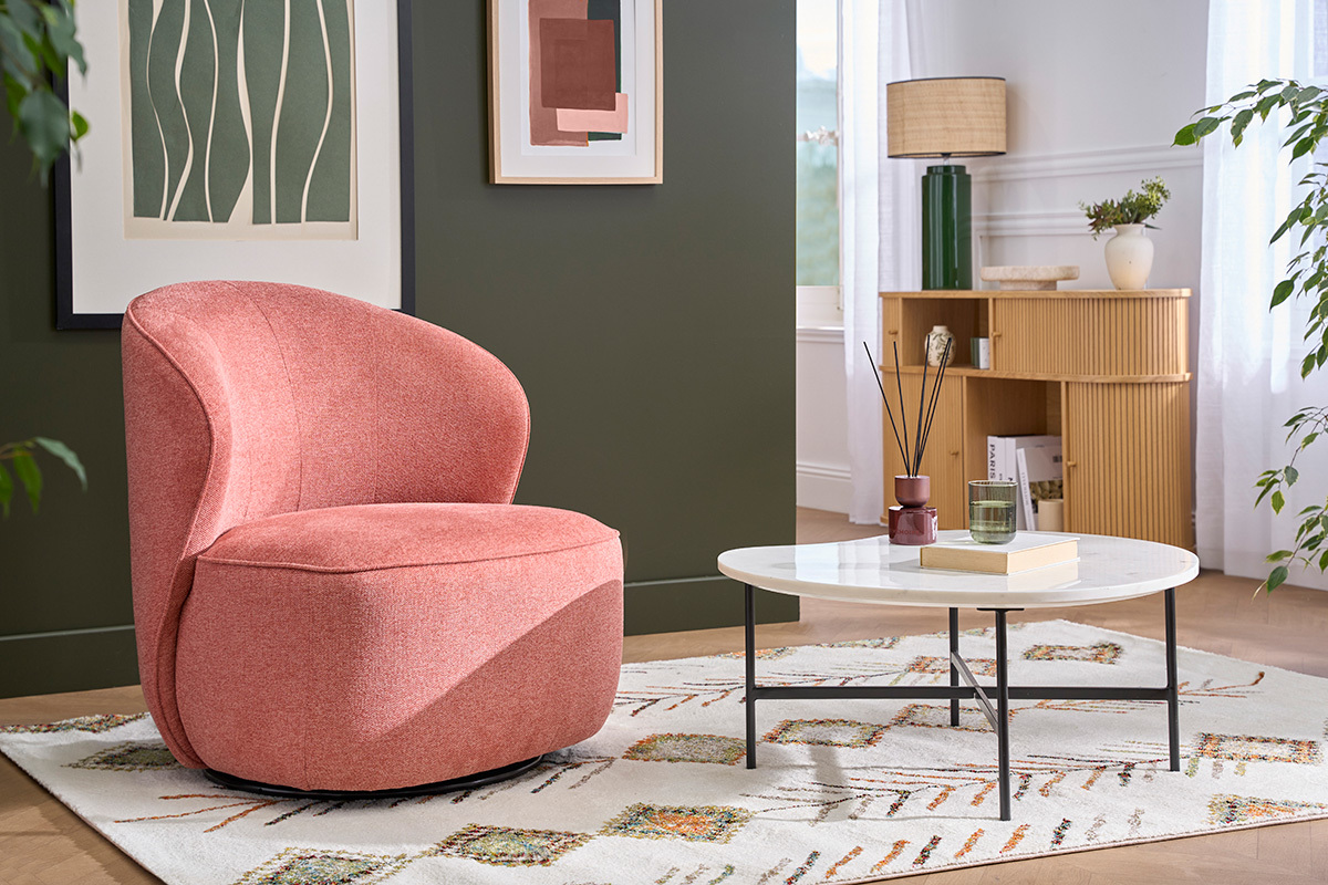 Poltrona design terracotta girevole in tessuto effetto velluto vista da 3/4, in un salotto con tavolino.