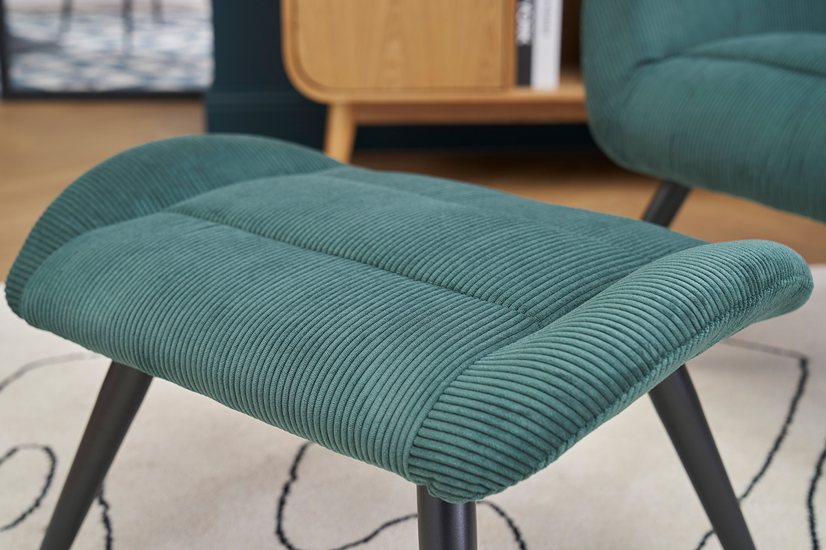 Poggiapiedi in velluto a coste verde con piedi in metallo nero, vista ravvicinata.