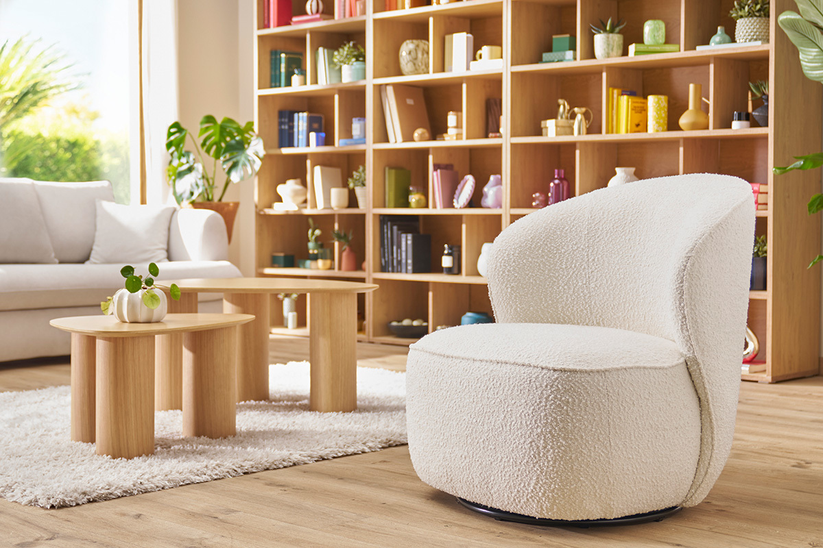 Fauteuil design girevole bianco, vista di profilo in un interno luminoso e moderno.